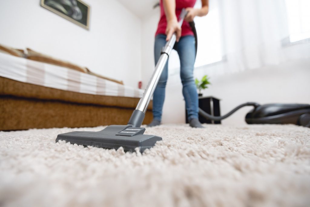 Woman cleaning a carpet with a hoover
