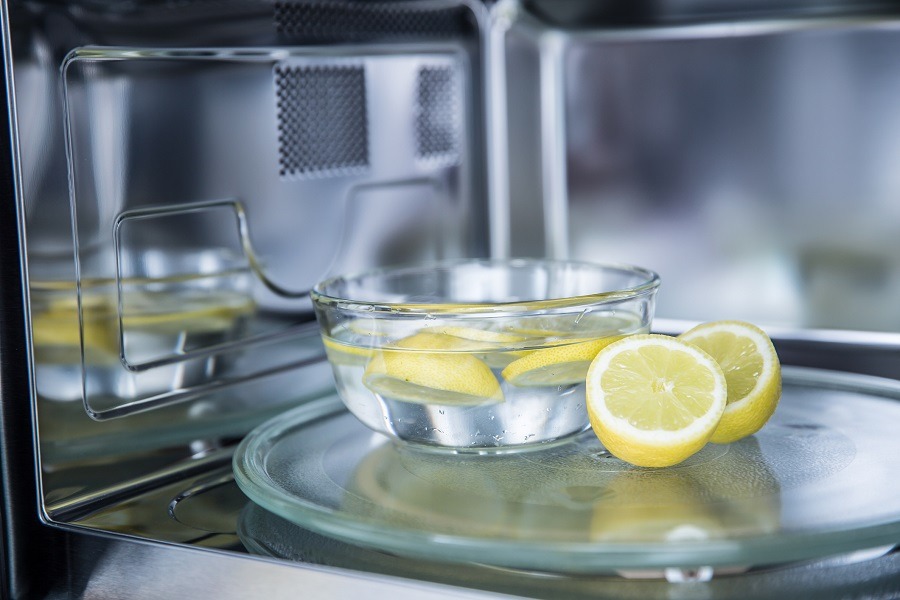 Slices of lemon in a bowl of water in a microwave to make it smell nice