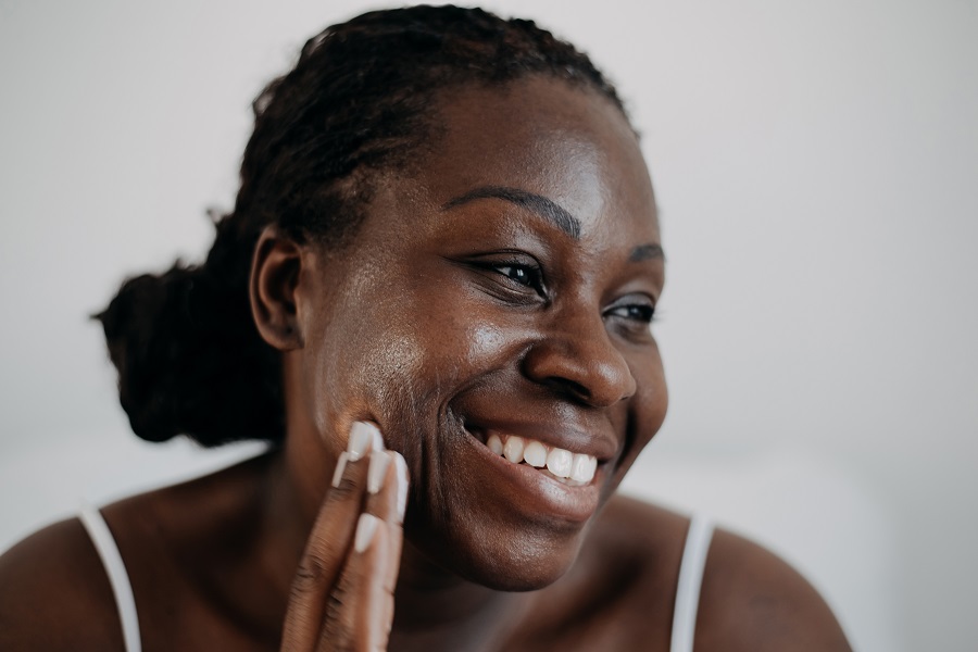 Lady applies suncream to her face