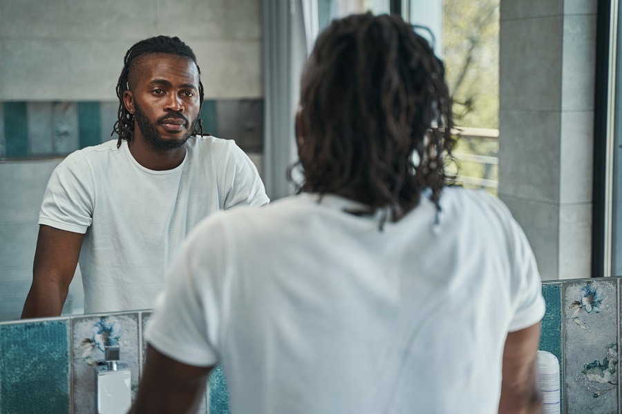 man looking at himself in the mirror straight-faced
