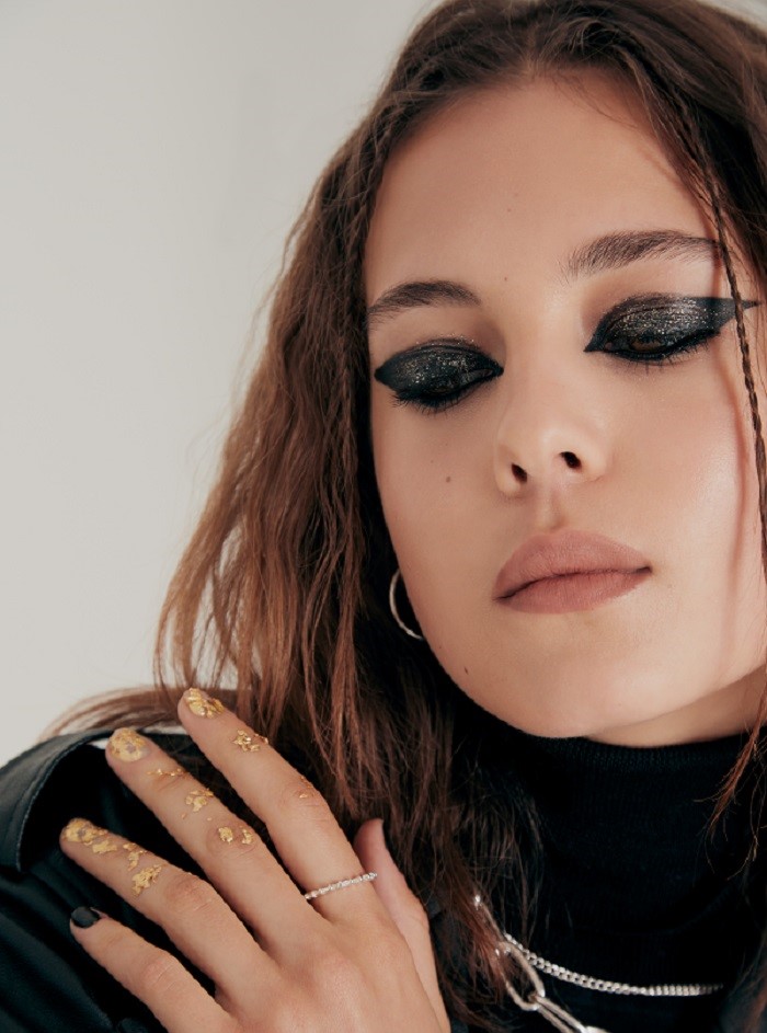 model looking down wearing thick black eye makeup 